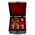 باکس هدیه سنتی ایرانی با روکش نقش‌دار، شامل زعفران نگین اصل، سه شیشه دمنوش منتخب و هاونگ برنجی طلایی؛ مناسب هدیه رسمی و پذیرایی شیک
