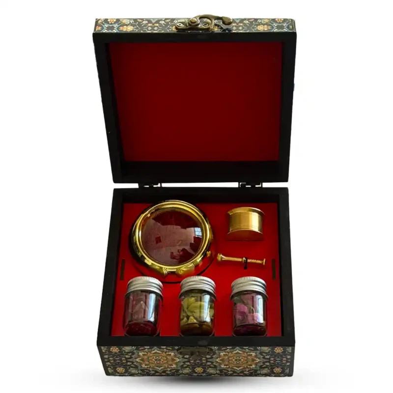 باکس هدیه سنتی ایرانی با روکش نقش‌دار، شامل زعفران نگین اصل، سه شیشه دمنوش منتخب و هاونگ برنجی طلایی؛ مناسب هدیه رسمی و پذیرایی شیک