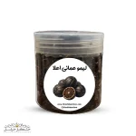 نمای نزدیک از پرک لیمو عمانی اعلا با رنگ قهوه‌ای روشن و بافت خشک در یک کاسه چوبی، مناسب استفاده در خورش‌های ایرانی.