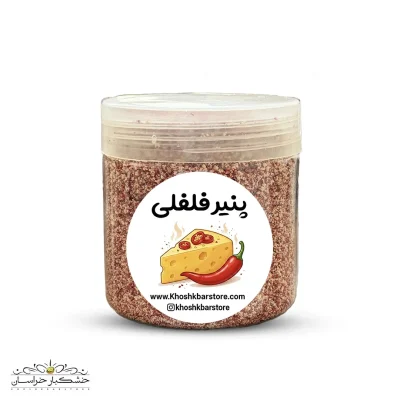 عکس آتلیه‌ای با پس‌زمینه تیره از پودر ادویه پنیر فلفلی نارنجی‌رنگ در کنار بادام‌زمینی‌های روکش‌دار پنیری و فلفل قرمز خشک شده جهت سئوی تصاویر سایت.